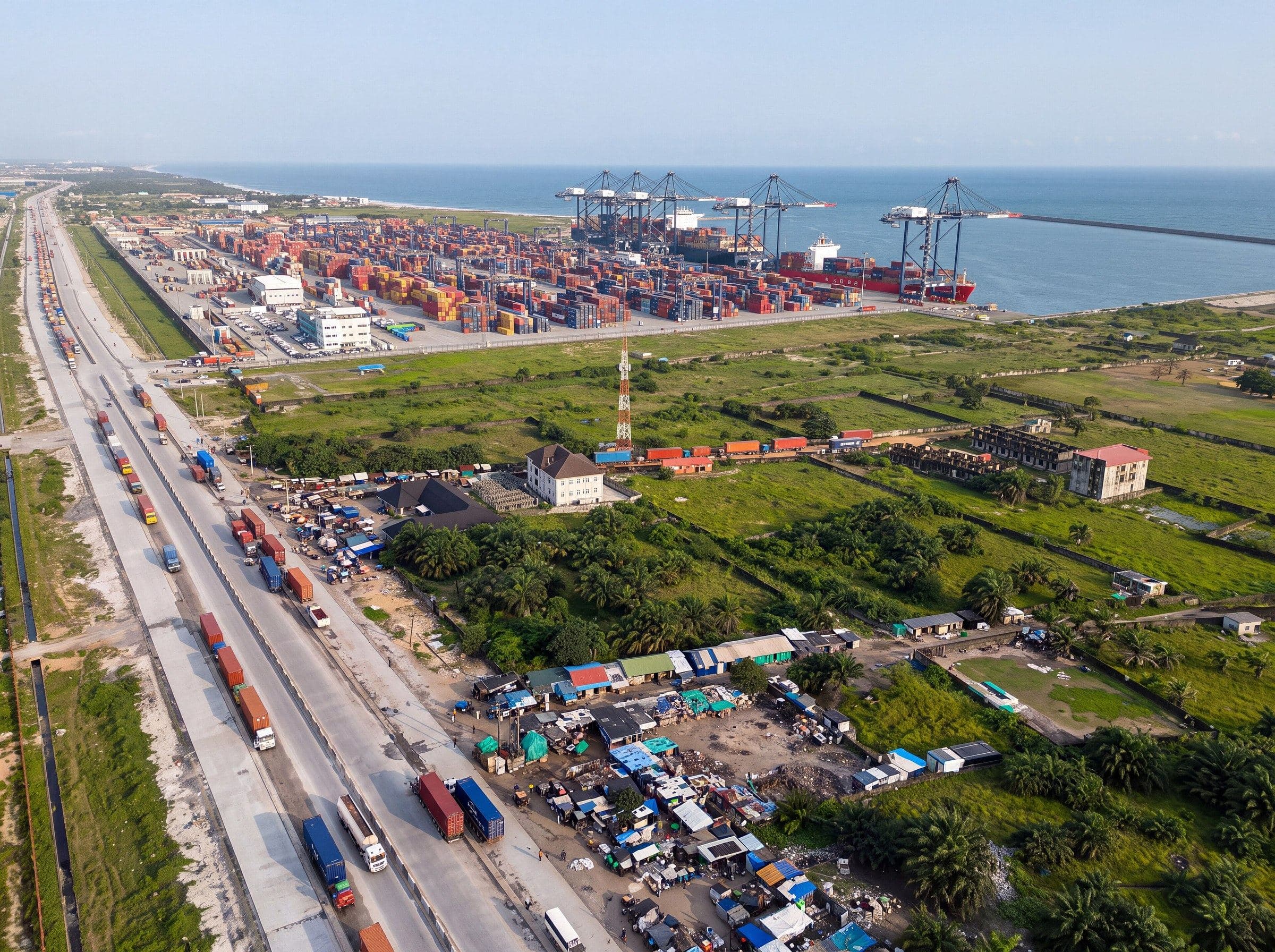 Lekki Deep Sea Port, Lagos, from the air: the container yard and ship-to-shore cranes by the Atlantic, with lorries queued on the expressway.